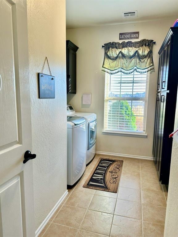 laundry room featuring cabinet space, baseboards, visible vents, and separate washer and dryer