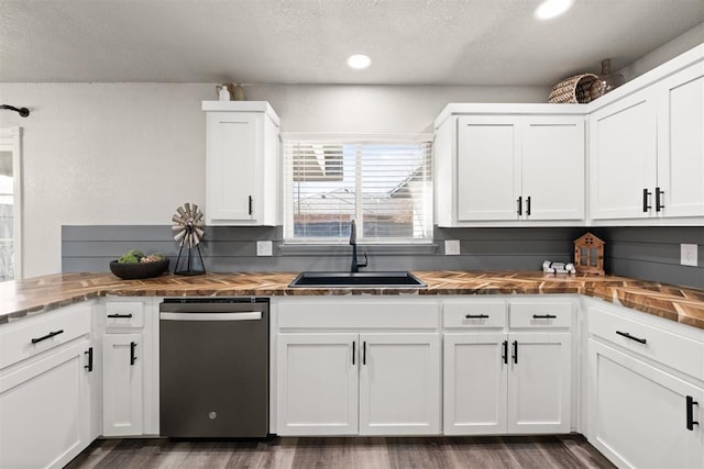 kitchen featuring stainless steel dishwasher, sink, and white cabinets