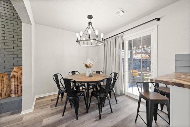 dining space with hardwood / wood-style flooring and a notable chandelier