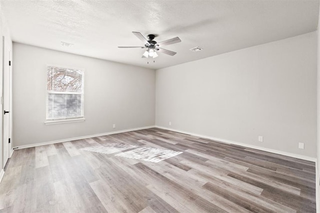 unfurnished room featuring hardwood / wood-style flooring, ceiling fan, and a textured ceiling