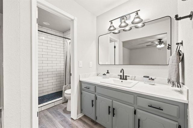 bathroom with hardwood / wood-style flooring, vanity, a shower with curtain, and toilet