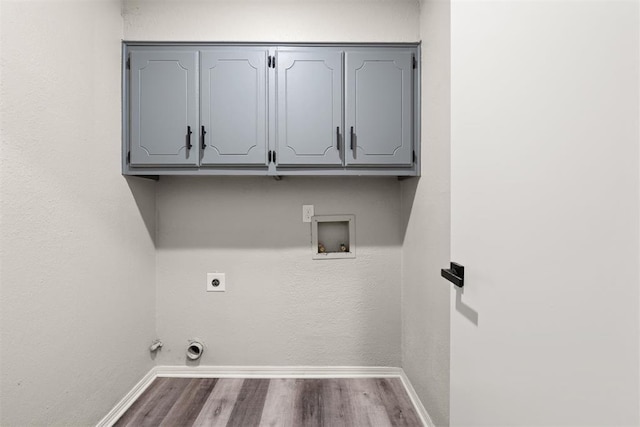 laundry area with cabinets, hookup for a washing machine, electric dryer hookup, hardwood / wood-style flooring, and hookup for a gas dryer