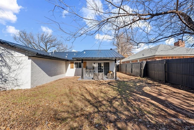 back of house with a lawn and a patio