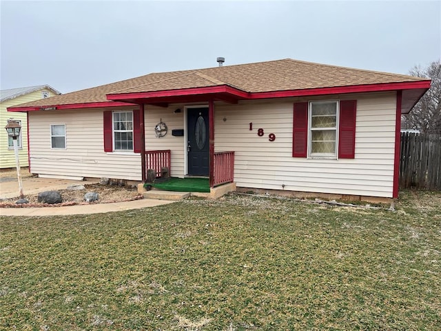 view of front of home featuring a shingled roof, a front yard, and fence