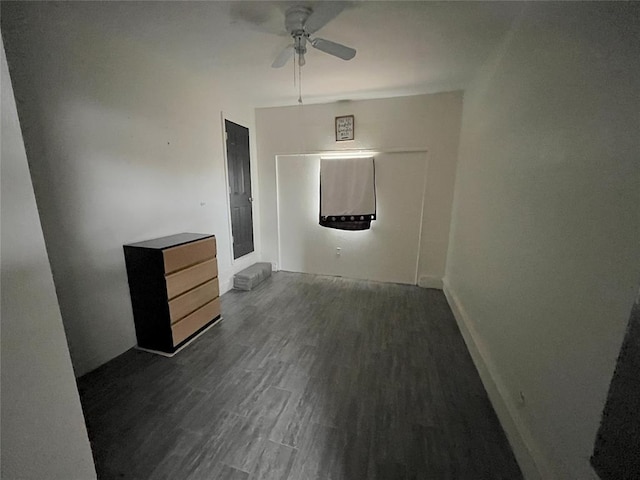 unfurnished bedroom featuring baseboards and dark wood-style flooring