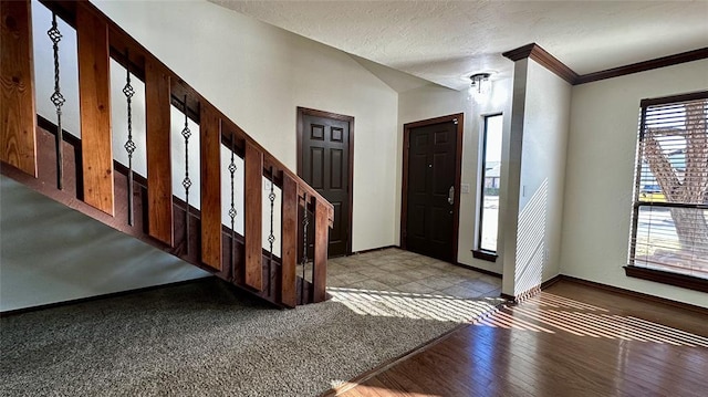 foyer with crown molding and a textured ceiling