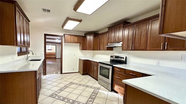 kitchen with sink, light tile patterned floors, and stainless steel electric range