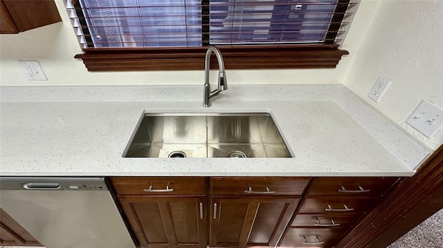 interior space with sink, stainless steel dishwasher, and light stone counters