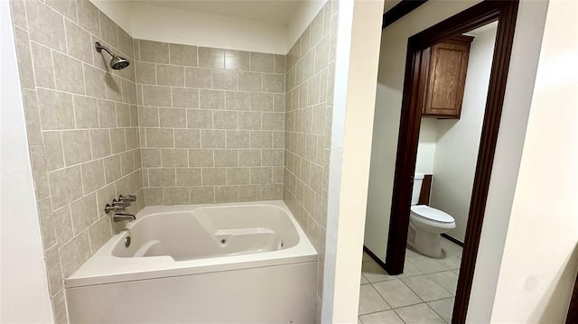 bathroom with tiled shower / bath combo, tile patterned flooring, and toilet