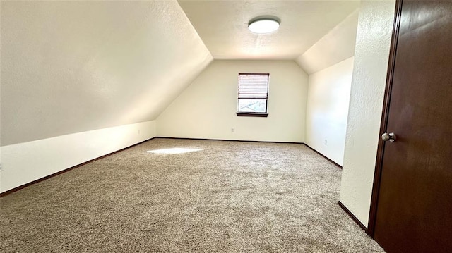 bonus room with lofted ceiling, carpet floors, and a textured ceiling