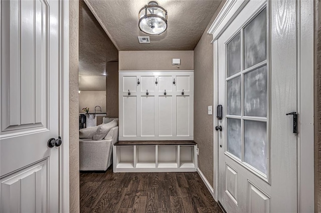 mudroom with dark hardwood / wood-style floors and a textured ceiling