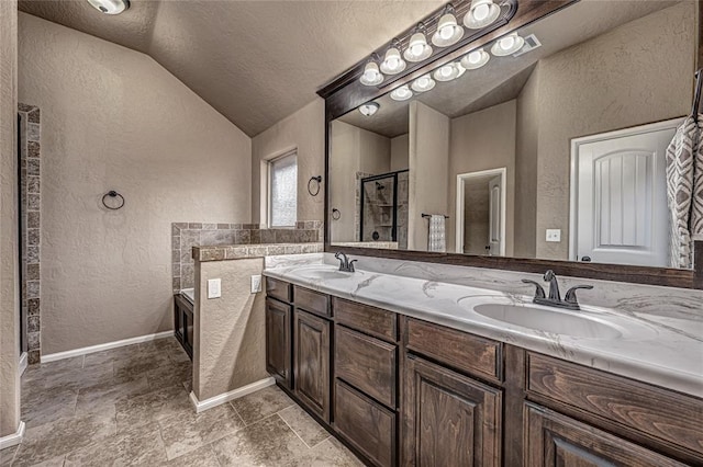 bathroom featuring vanity, vaulted ceiling, a textured ceiling, and a shower