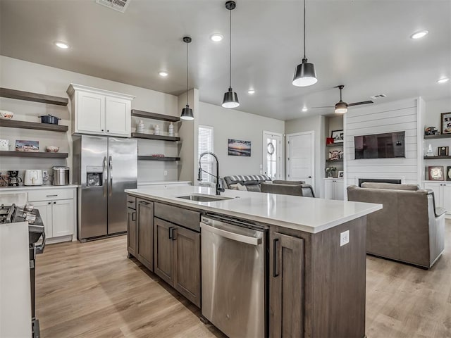 kitchen featuring appliances with stainless steel finishes, sink, pendant lighting, and white cabinets