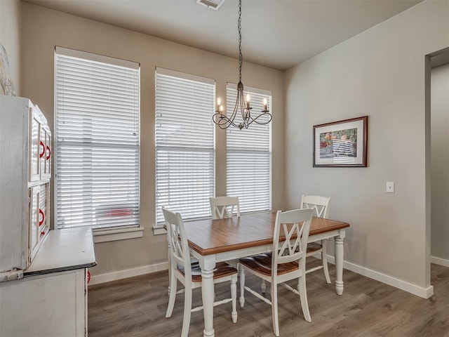 dining room with visible vents, baseboards, an inviting chandelier, and wood finished floors