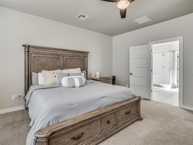 bedroom with ceiling fan, light colored carpet, and connected bathroom