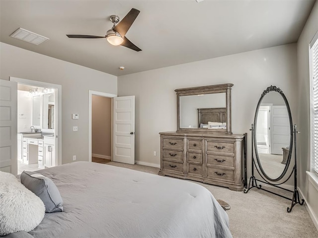 bedroom with light carpet, ceiling fan, and ensuite bathroom