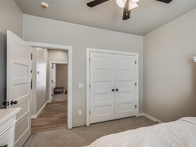 carpeted bedroom with ceiling fan and a closet