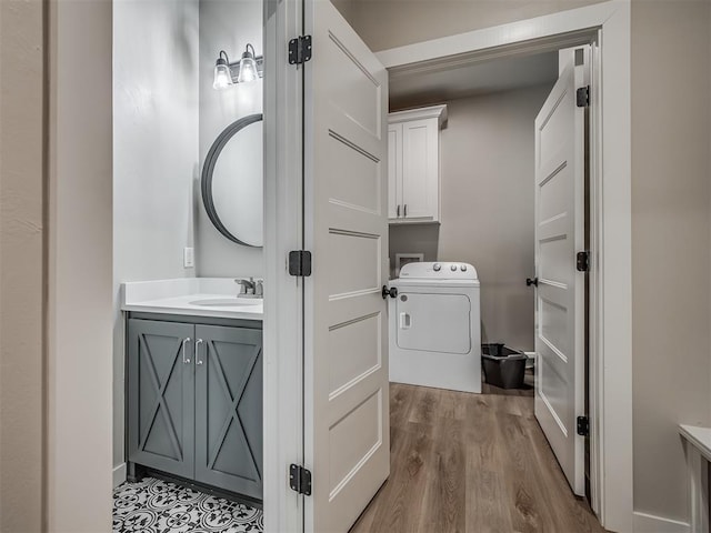 half bath with washer / clothes dryer, toilet, wood finished floors, and vanity