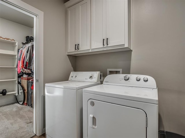 laundry area with independent washer and dryer, light colored carpet, and cabinets