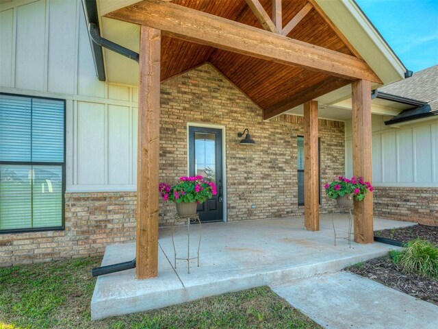 19001 Bobcat Ridge Ct, Cashion, OK 73016 - entrance to property featuring board and batten siding, brick siding, a porch, and roof with shingles