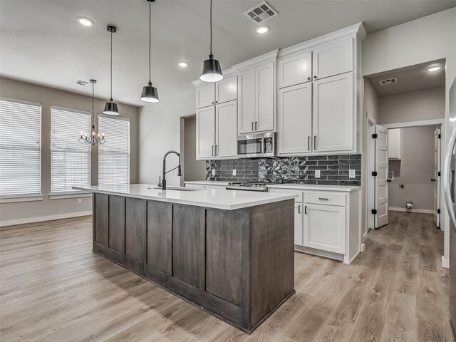 19001 Bobcat Ridge Ct, Cashion, OK 73016 - kitchen with a sink, stainless steel microwave, light countertops, backsplash, and baseboards