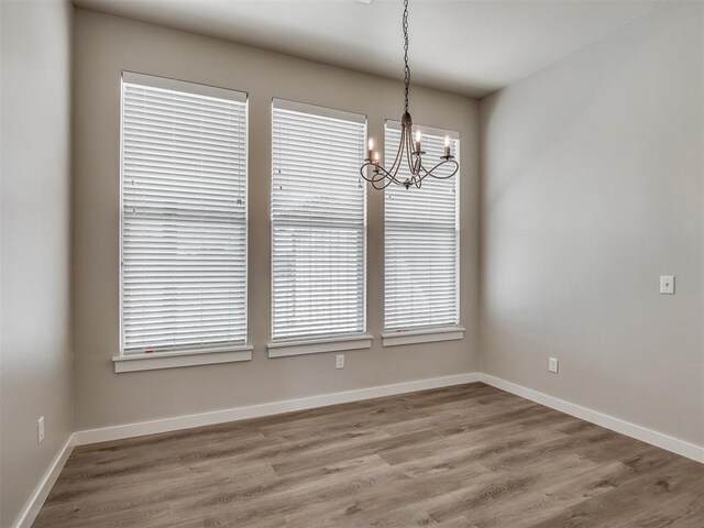 19001 Bobcat Ridge Ct, Cashion, OK 73016 - unfurnished dining area featuring a chandelier, wood finished floors, baseboards, and plenty of natural light