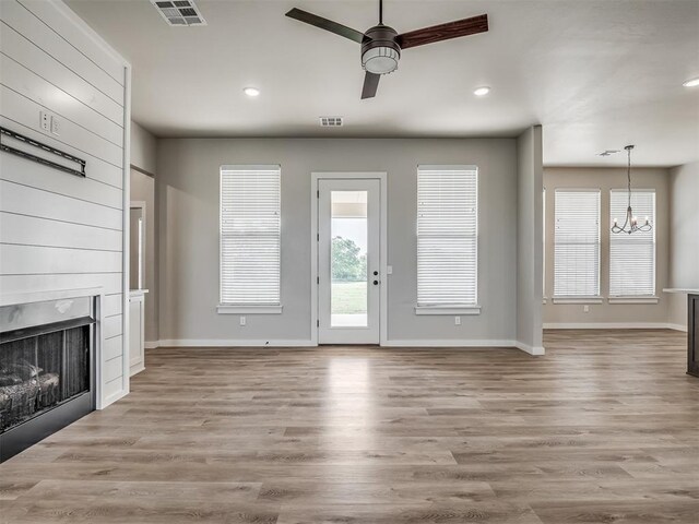 19001 Bobcat Ridge Ct, Cashion, OK 73016 - unfurnished living room featuring a chandelier, a ceiling fan, a large fireplace, wood finished floors, and recessed lighting