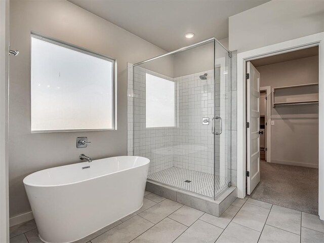 19001 Bobcat Ridge Ct, Cashion, OK 73016 - full bathroom featuring a shower stall, baseboards, a spacious closet, a freestanding bath, and tile patterned floors