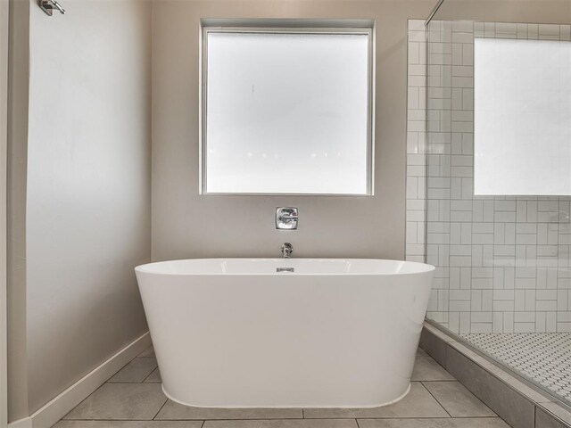 19001 Bobcat Ridge Ct, Cashion, OK 73016 - full bath with tile patterned flooring, tiled shower, a freestanding bath, and baseboards