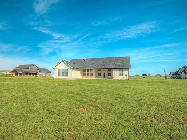 19001 Bobcat Ridge Ct, Cashion, OK 73016 - rear view of property featuring board and batten siding, a lawn, and roof with shingles