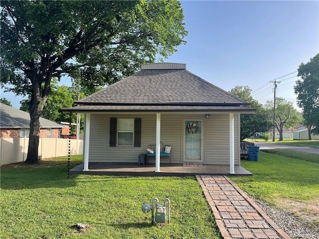 rear view of house featuring a lawn