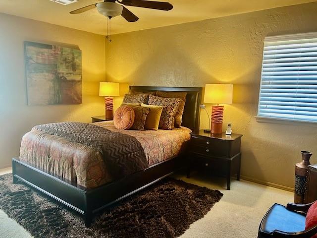 bedroom featuring light carpet and ceiling fan