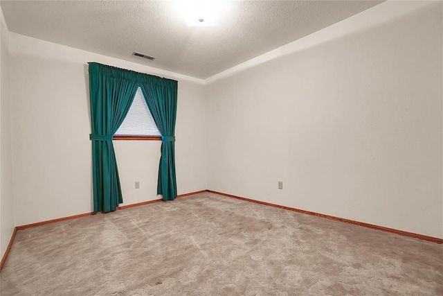 carpeted spare room with a textured ceiling