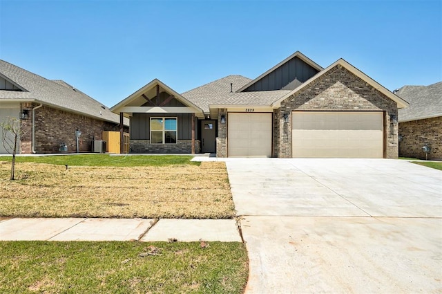 view of front of house with a garage, central AC, and a front lawn