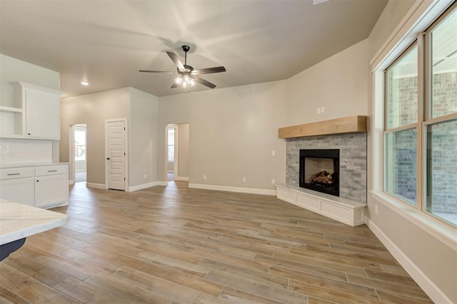 unfurnished living room with ceiling fan, a healthy amount of sunlight, and light wood-type flooring