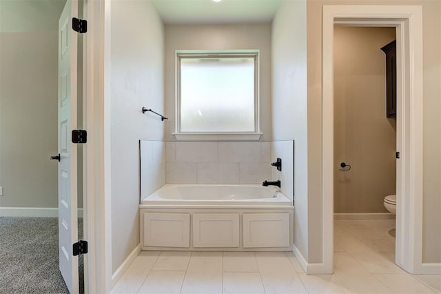 bathroom with toilet, tile patterned floors, and a tub to relax in