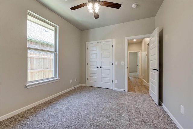 unfurnished bedroom featuring light carpet, ceiling fan, and a closet