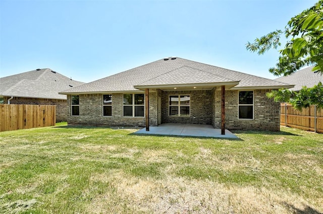 back of property with a lawn and a patio