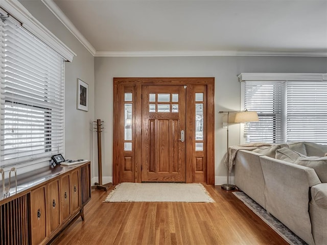 foyer with baseboards, light wood-type flooring, and crown molding