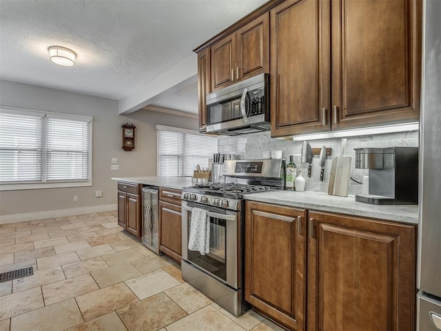 kitchen with stainless steel appliances, backsplash, visible vents, and a healthy amount of sunlight