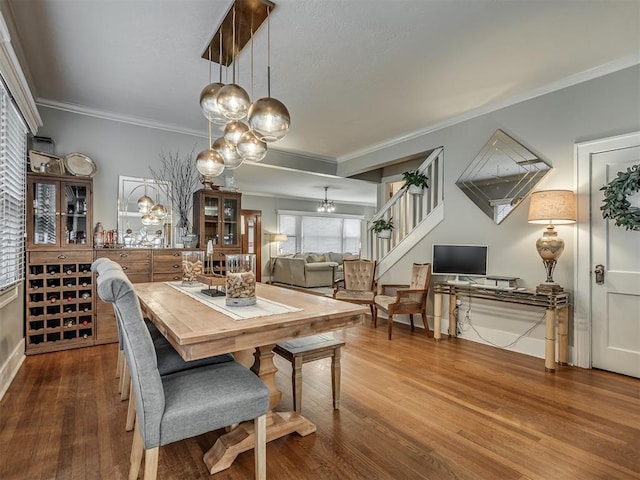 dining area with stairs, crown molding, and wood finished floors