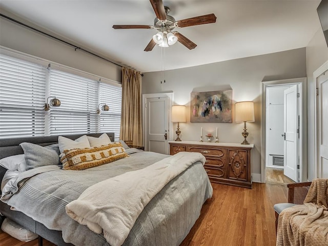 bedroom with light wood-type flooring, visible vents, and a ceiling fan