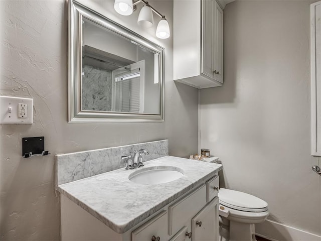 half bathroom with vanity and toilet