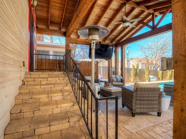 view of patio / terrace featuring ceiling fan, fence, and an outdoor living space