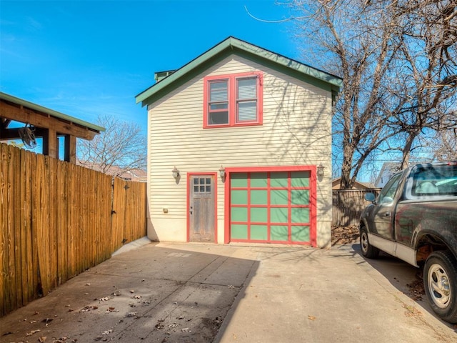 exterior space featuring concrete driveway and fence