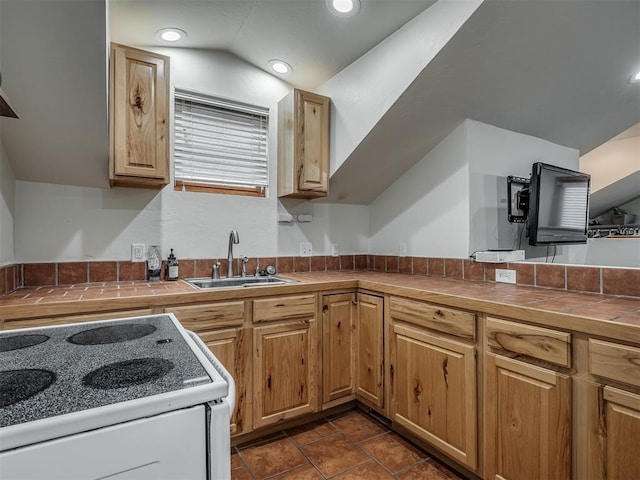 kitchen featuring electric stove, tile countertops, recessed lighting, vaulted ceiling, and a sink