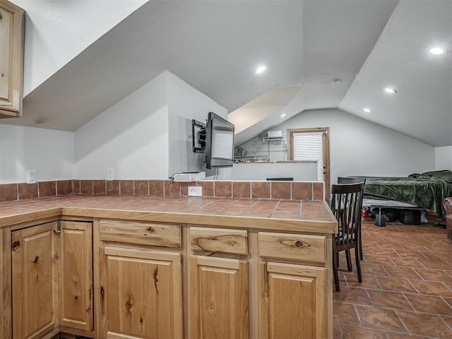 kitchen featuring lofted ceiling, open floor plan, tile counters, and recessed lighting