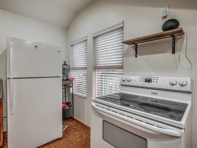 kitchen featuring tile patterned flooring, white appliances, and vaulted ceiling