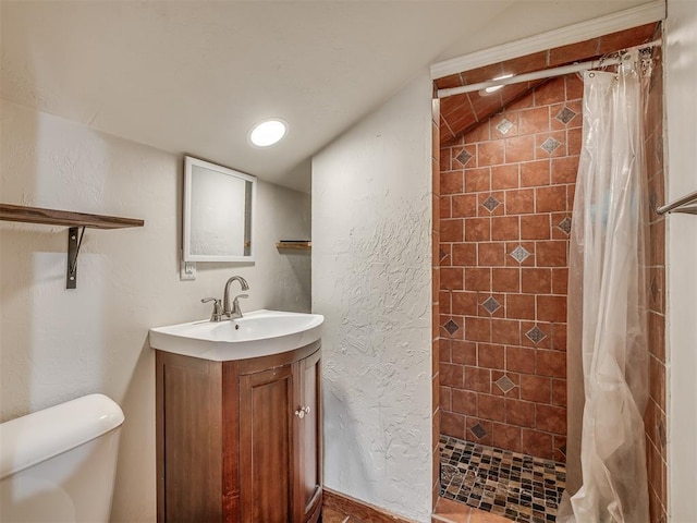 full bath with toilet, a stall shower, a textured wall, and vanity