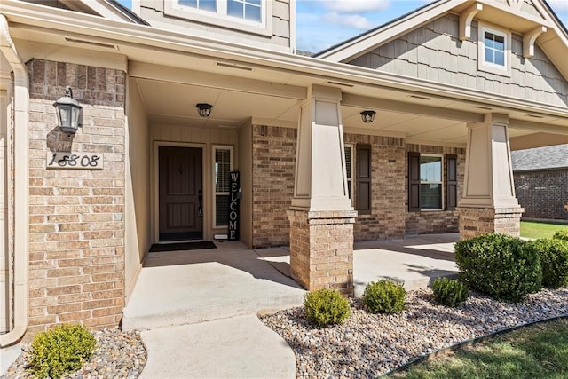 view of exterior entry featuring covered porch